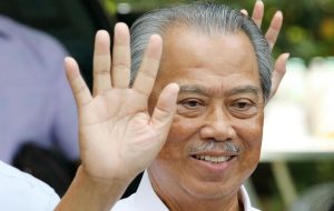 Malaysia's Prime Minister Designate and former interior minister Muhyiddin Yassin waves to reporters outside his residence in Kuala Lumpur